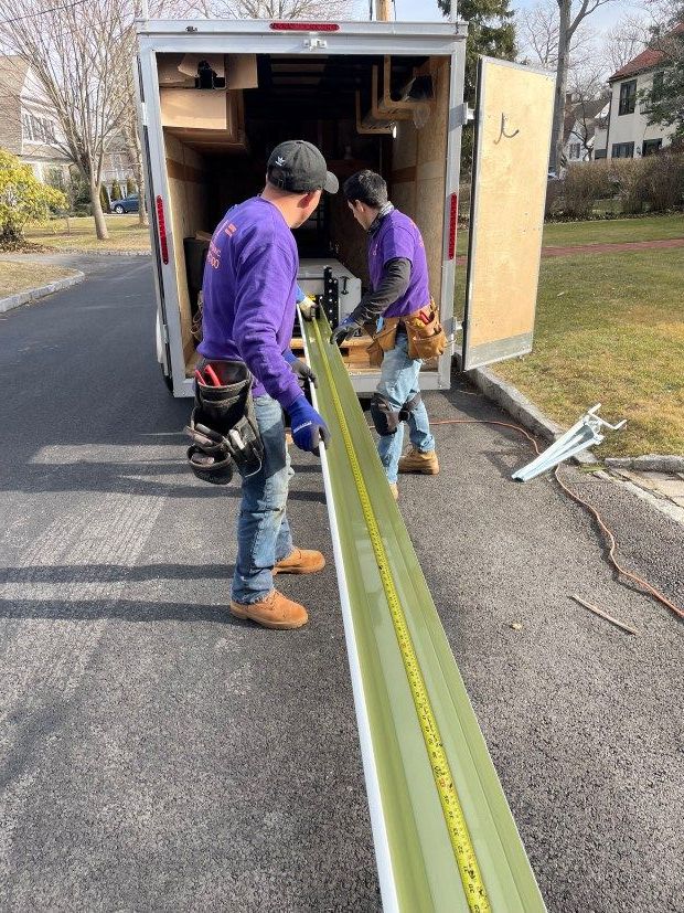 Westchester Roofing workers pulling out a gutter from a company work truck